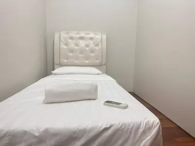a bed with a remote control sitting on top of it at Soho Suites KLCC By Grand KL in Kuala Lumpur