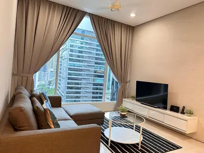 a living room with a couch and a large window at Soho Suites KLCC By Grand KL in Kuala Lumpur