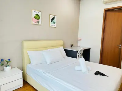 a small bedroom with a bed with a white bedspread at Soho Suites KLCC By Grand KL in Kuala Lumpur
