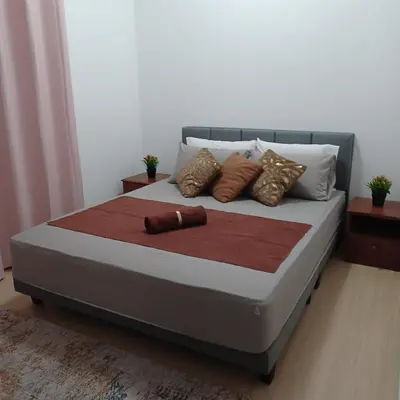a bed with several pillows on it in a room at M Centura Sentul 2 bedrooms with pool in Kuala Lumpur