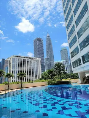 a large swimming pool in a city with tall buildings at single room in klcc in Kuala Lumpur