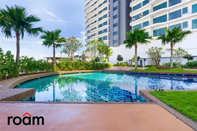 a swimming pool in front of a building with palm trees at Datum Jelatek Sky Residence Kuala Lumpur, Roam in Kuala Lumpur