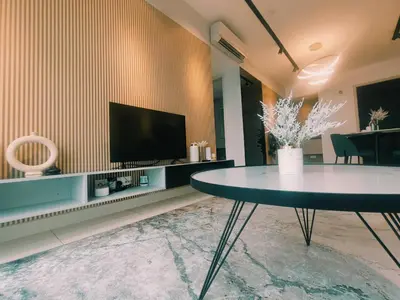 a living room with a table and a flat screen tv at Datum Jelatek, Sky Ring in Kuala Lumpur