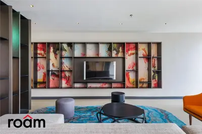 a living room with a tv on a wall at ViiA Residences Kuala Lumpur in Kuala Lumpur