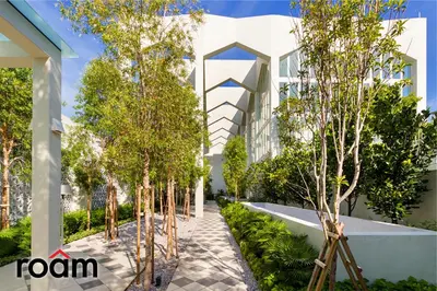 an exterior view of a building with trees lining a sidewalk at UNA Residences, Sunway KL in Kuala Lumpur