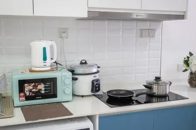 a kitchen counter with a stove and a microwave at Continew 1BR High TRX Mall King Bed 100Mbps Wi-Fi in Kuala Lumpur
