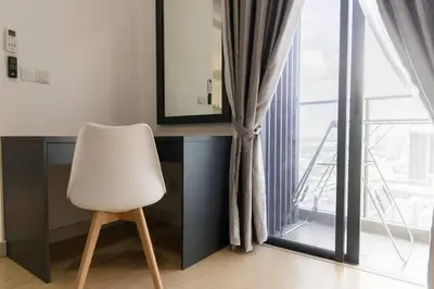 a white chair sitting in front of a desk with a mirror at Continew 1BR High TRX Mall King Bed 100Mbps Wi-Fi in Kuala Lumpur