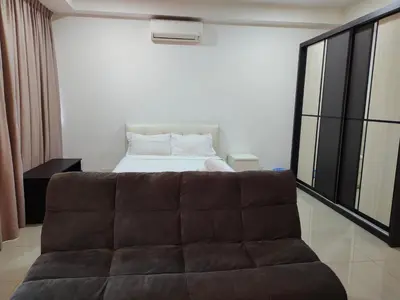 a couch in front of a bed in a room at Arte plus by sweet home studio in Kuala Lumpur