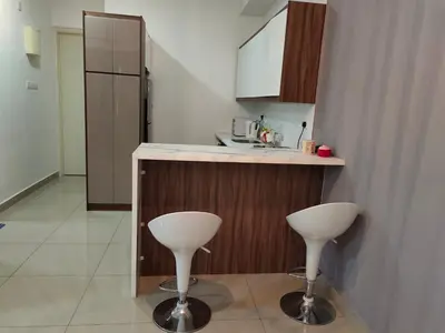 a kitchen with two white stools next to a counter at Arte plus by sweet home studio in Kuala Lumpur