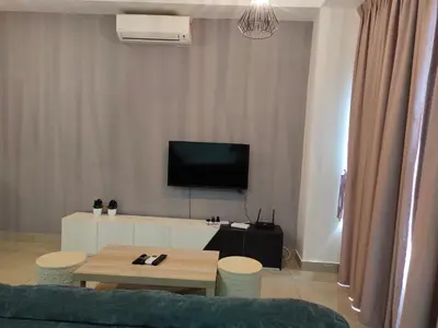 a living room with a couch and a table and a tv at Arte plus by sweet home studio in Kuala Lumpur