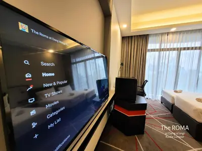 a room with a large flat screen tv in a hotel room at The Roma at Dang Wangi Kuala Lumpur in Kuala Lumpur