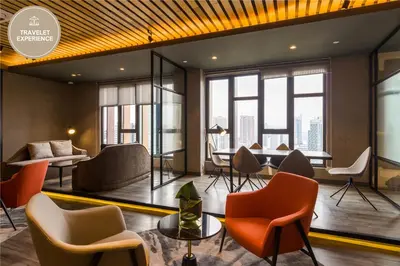 a lobby with chairs and tables and windows at Ceylonz Suite KLCC, Travelet in Kuala Lumpur