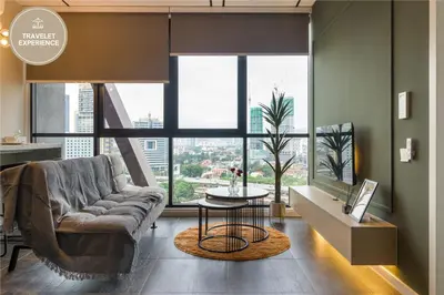 a living room with a couch and a large window at Scarletz Suites KLCC, Travelet in Kuala Lumpur
