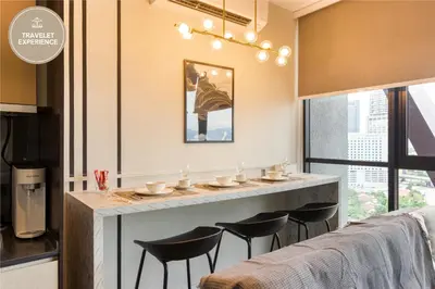 a kitchen with a bar with black stools at Scarletz Suites KLCC, Travelet in Kuala Lumpur