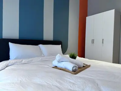 a white bed with a tray with towels on it at KL Trion Residence near Velocity - IKEA - Lalaport - Bukit Bintang in Kuala Lumpur