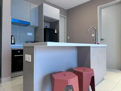 a kitchen with a counter and two stools at KL Trion Residence near Velocity - IKEA - Lalaport - Bukit Bintang in Kuala Lumpur