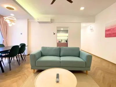 a living room with a green couch and a table at KAĨTE Homestay at Fahrenheit88 Bukit Bintang, Opposite Pavilion KL in Kuala Lumpur