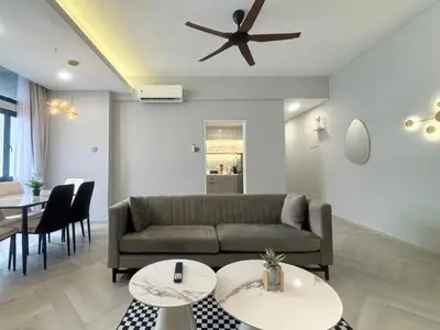 a living room with a couch and two tables at KAĨTE Homestay at Fahrenheit88 Bukit Bintang, Opposite Pavilion KL in Kuala Lumpur