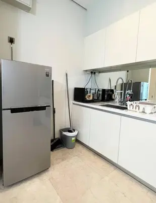 a kitchen with white cabinets and a refrigerator at Soho Suites, Centrally Located at KL City Centre in Kuala Lumpur