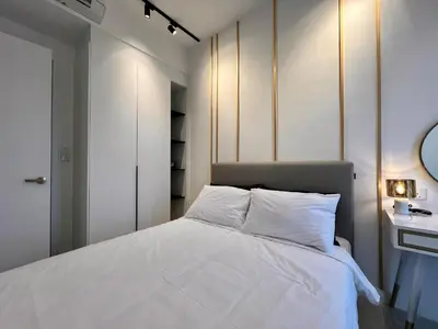 a bedroom with a bed with white sheets and a mirror at Axon Residence Bukit Bintang Kuala Lumpur By Apex in Kuala Lumpur