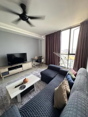 a living room with a blue couch and a ceiling fan at Queen Room At KL Gateway Residence LRT Linked in Kuala Lumpur