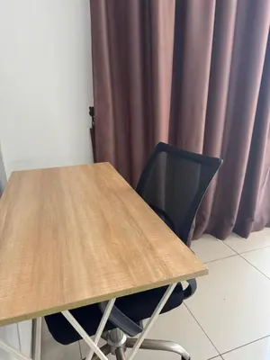 a wooden table with a black chair next to a curtain at Queen Room At KL Gateway Residence LRT Linked in Kuala Lumpur