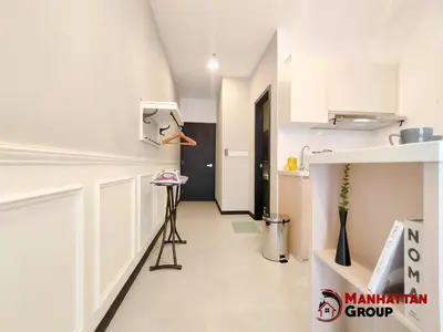 a kitchen with white cabinets and a hallway at Neu Suites By Manhattan Group in Kuala Lumpur
