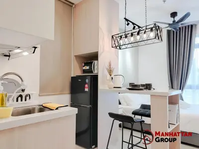 a kitchen with a sink and a black refrigerator at Neu Suites By Manhattan Group in Kuala Lumpur
