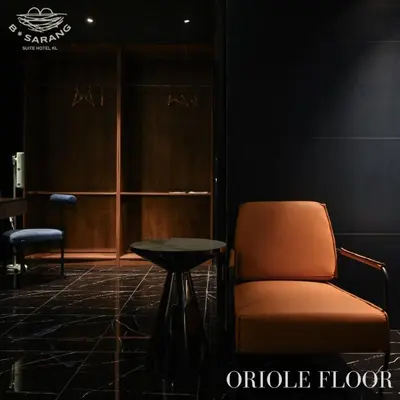 an orange chair and a table in a room at B Sarang Suite Hotel Kuala Lumpur in Kuala Lumpur