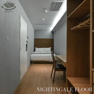 a bedroom with a bed and a desk and a bed and a table at B Sarang Suite Hotel Kuala Lumpur in Kuala Lumpur