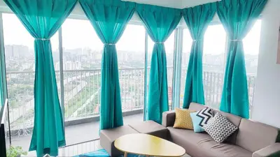 a living room with blue curtains and a couch in front of a window at YOLO Budget Condo KL 5.0 in Kuala Lumpur