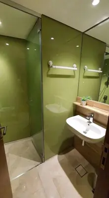 a green bathroom with a sink and a shower at sky suite klcc in Kuala Lumpur