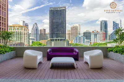 a city skyline with a purple couch and white chairs at Quill Residences Kuala Lumpur, Five Senses in Kuala Lumpur