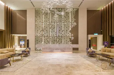 a lobby with a fireplace and a large screen at Quill Residences Kuala Lumpur, Five Senses in Kuala Lumpur