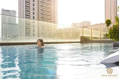 a woman in a swimming pool on a building at Quill Residences Kuala Lumpur, Five Senses in Kuala Lumpur