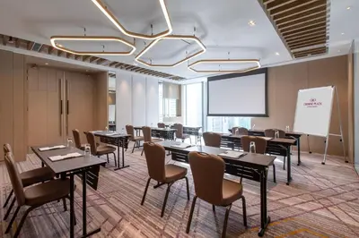 a conference room with tables and chairs and a whiteboard at Crowne Plaza Kuala Lumpur City Centre by IHG in Kuala Lumpur