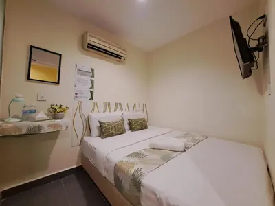 a bedroom with two beds and a tv on the wall at SCC Gateway Chinatown Hotel in Kuala Lumpur
