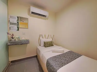 a small room with two beds and a air conditioner at SCC Gateway Chinatown Hotel in Kuala Lumpur