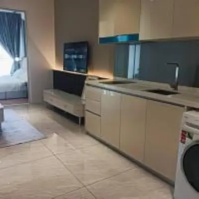 a kitchen with a sink and a couch in a room at Quill Residence KLCC in Kuala Lumpur