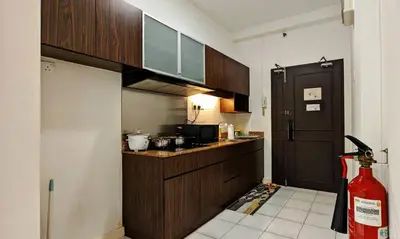 a kitchen with wooden cabinets and a counter top at Electus Suite in Kuala Lumpur
