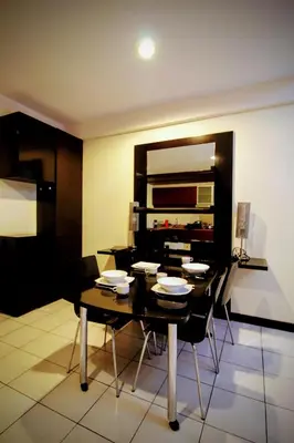 a dining room with a black table and chairs at Electus Suite in Kuala Lumpur