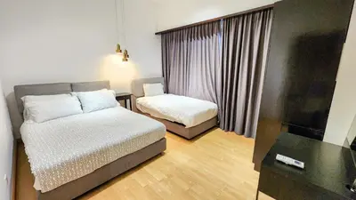 a small bedroom with two beds and a window at Electus Suite in Kuala Lumpur