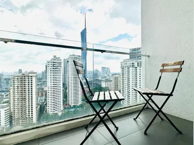 two chairs on a balcony with a view of a city at One Bukit ceylon @ Bukit Bintang City Centre in Kuala Lumpur