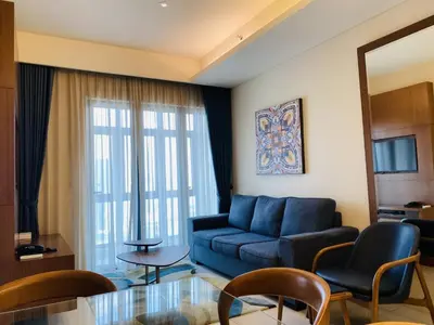 a living room with a blue couch and a table at Tribeca Serviced Hotel by Millennium in Kuala Lumpur