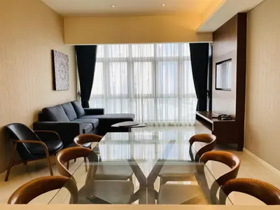a living room with a glass table and chairs at Tribeca Serviced Hotel by Millennium in Kuala Lumpur