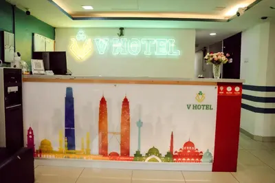 a sign for a hotel with a mural of cities at V Hotel Titiwangsa in Kuala Lumpur