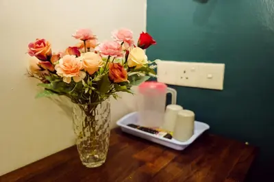a vase of flowers on a table with candles at V Hotel Titiwangsa in Kuala Lumpur