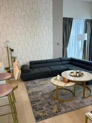 a living room with a black couch and tables at Klcc suites at star - 2 bedroom in Kuala Lumpur