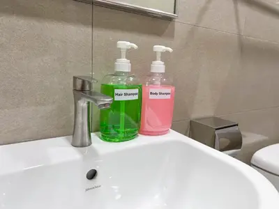 two soap bottles sitting on top of a bathroom sink at MH Maison by Manhattan Group in Kuala Lumpur