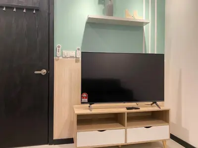 a flat screen tv sitting on a stand next to a door at Neu Suite by JS Home in Kuala Lumpur